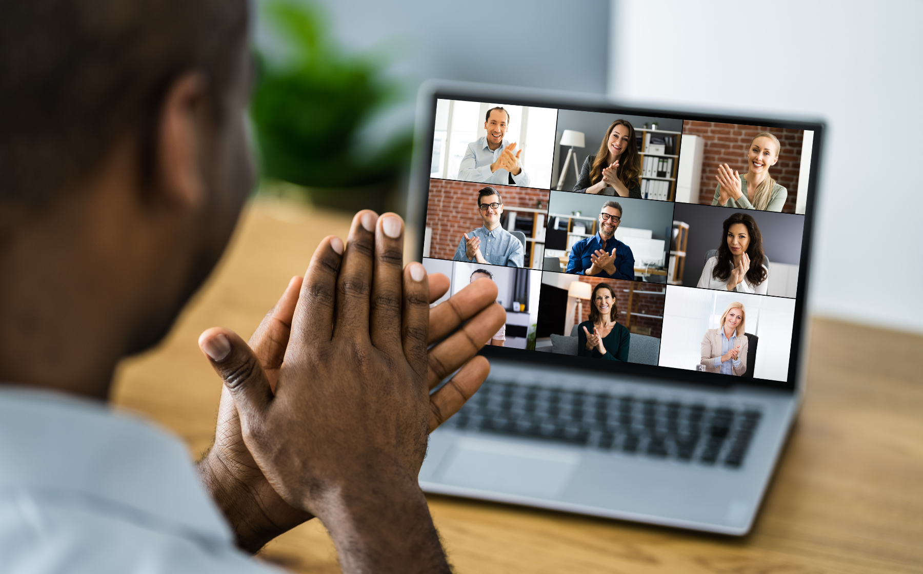 A person claps at a video call of teammates applauding